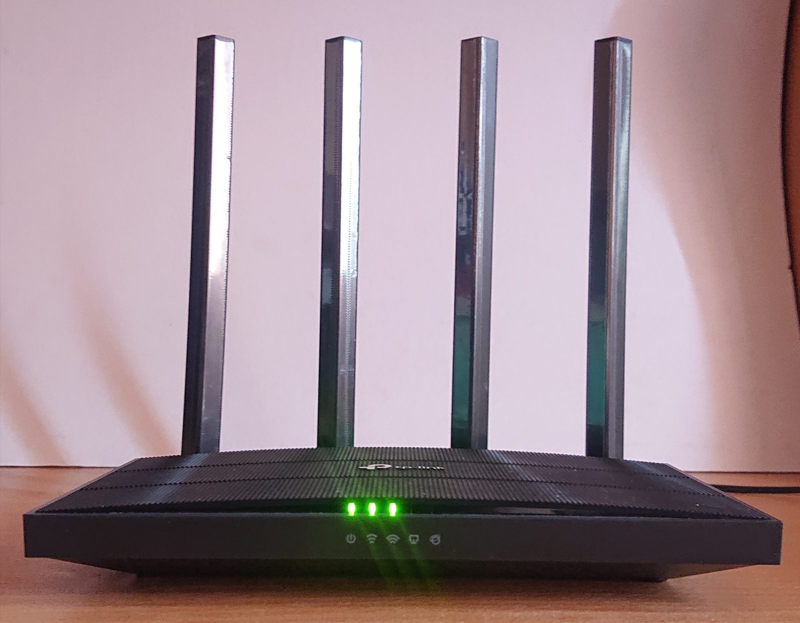 A TP-Link Archer A6 router, front side, powered on with its status LEDs lit.